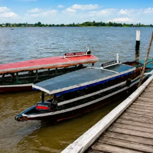 Houten aanlegsteiger met boot aan tropische rivier