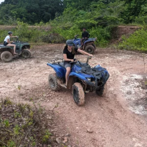 Toeristen rijden op ATV's over een brede jungleweg
